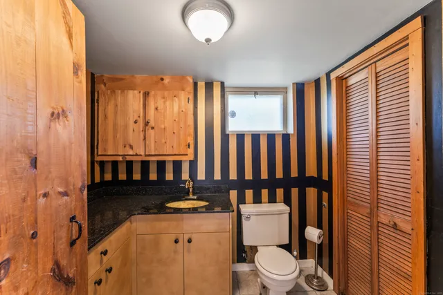 a bathroom with a toilet a sink and a mirror