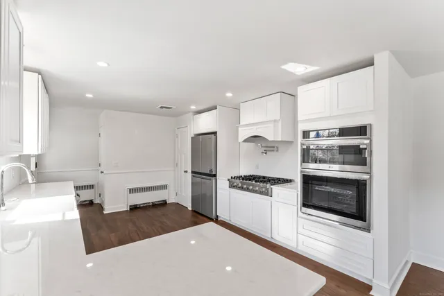 a kitchen with granite countertop a stove and a refrigerator