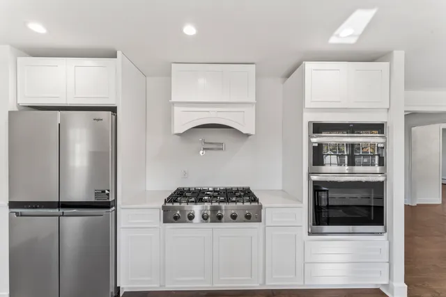 a kitchen with a refrigerator and a stove top oven