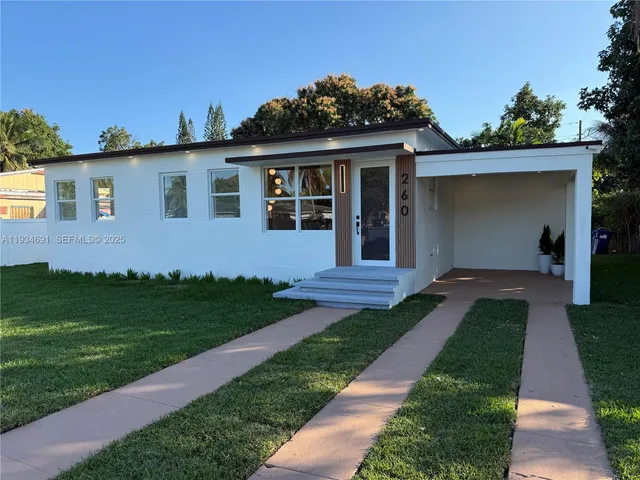 a front view of a house with a garden and yard