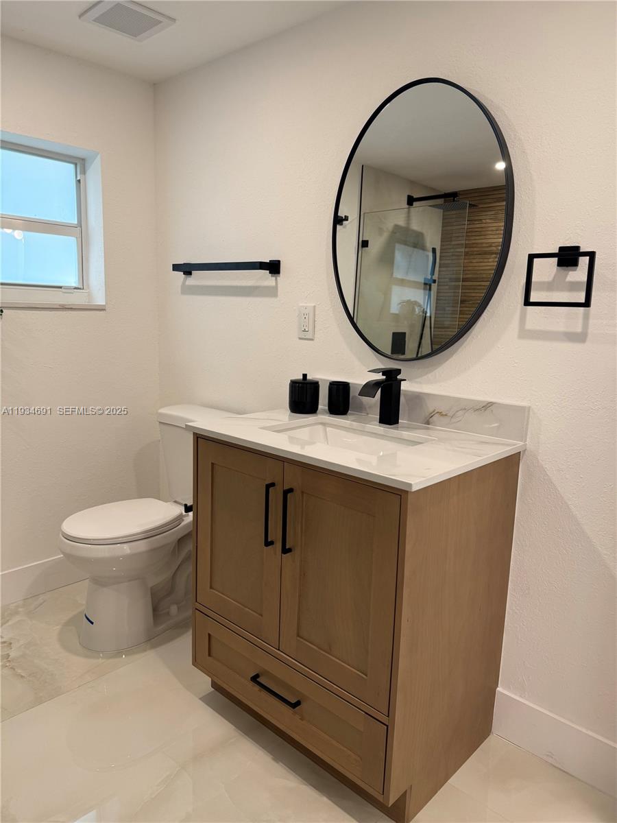 260 Northwest 119th Street Miami, FL 33168 - Photo 12 of 31 a bathroom with a toilet mirror and vanity