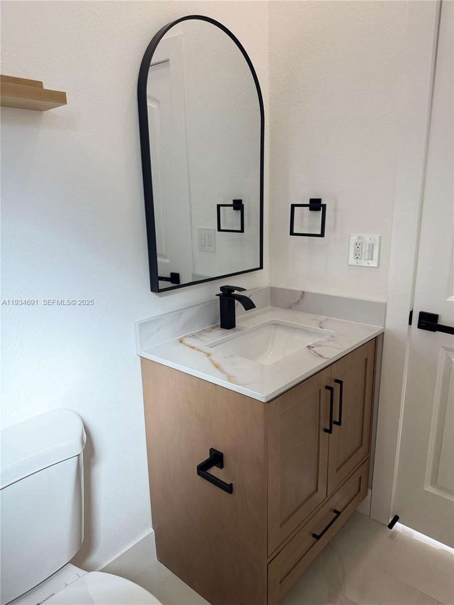 260 Northwest 119th Street Miami, FL 33168 - Photo 18 of 31 a bathroom with a granite countertop sink a toilet and mirror