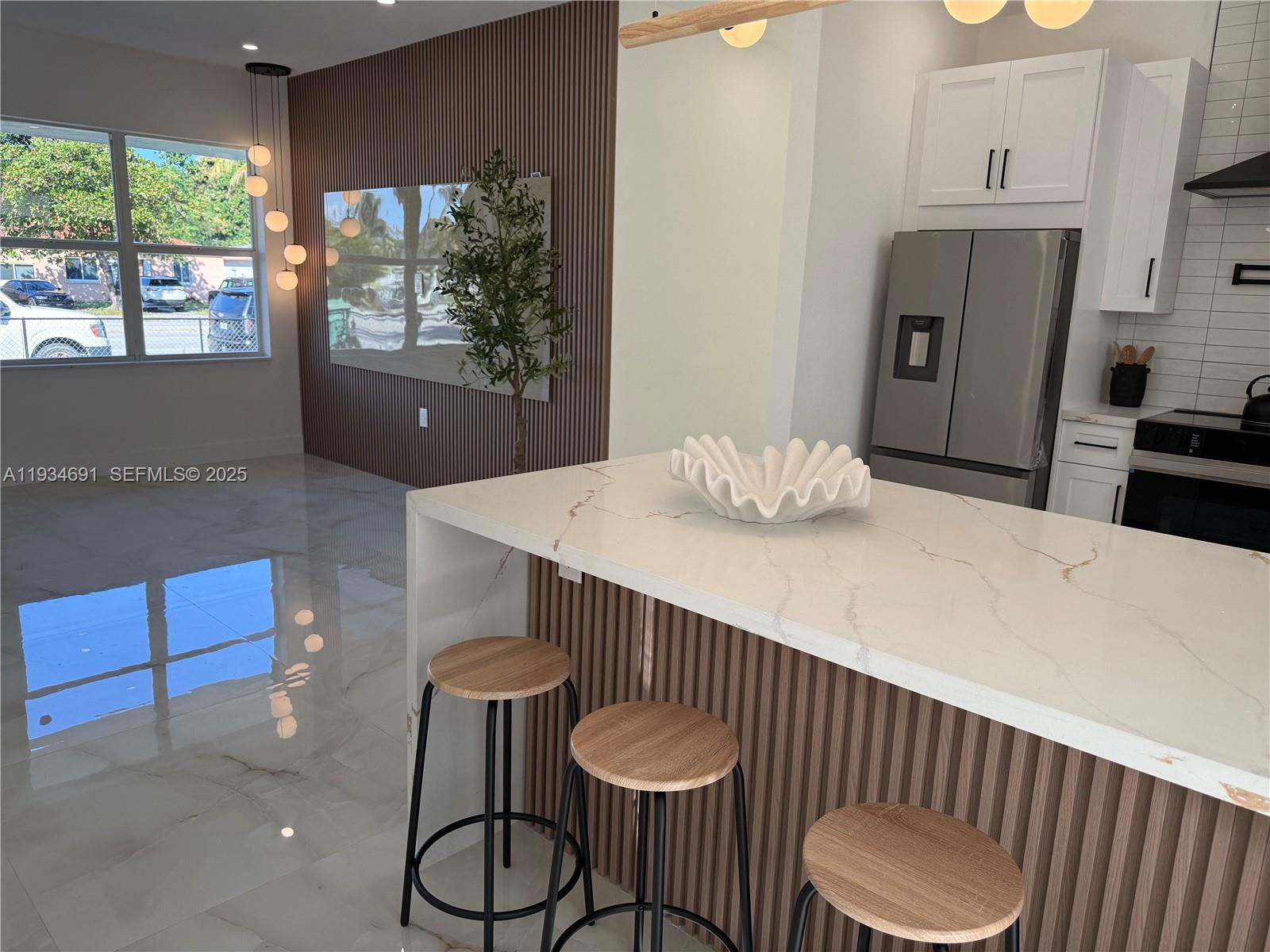 260 Northwest 119th Street Miami, FL 33168 - Photo 8 of 31 a kitchen with granite countertop a table chairs and white cabinets