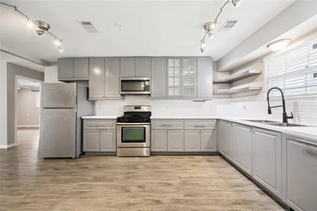 a kitchen with a refrigerator sink and white cabinets