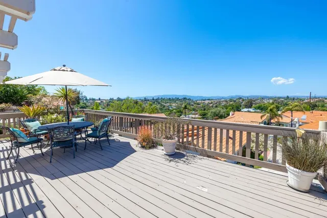 a view of a patio with a table and chairs under an umbrella