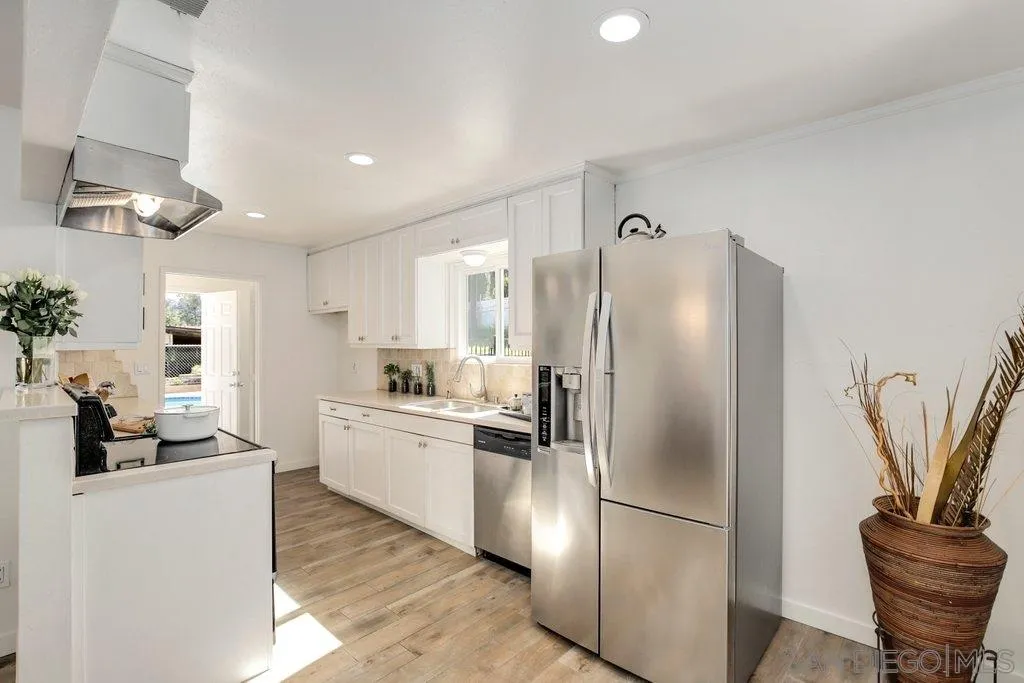 2809 Reed Road Escondido, CA 92027 - Photo 3 of 25 a kitchen with stainless steel appliances granite countertop a refrigerator a stove a sink and a dining table with wooden floor