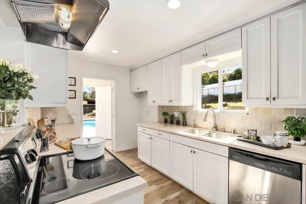2809 Reed Road Escondido, CA 92027 - Photo 4 of 25 a kitchen with a dining table chairs sink and cabinets