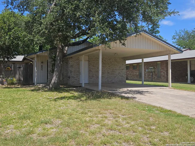 a view of a house with backyard and tree
