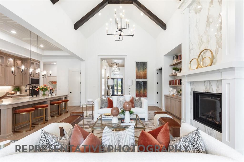 3808 Meander Way Prosper, TX 75078 - Photo 16 of 40 a view of a livingroom with furniture a fireplace a chandelier and windows