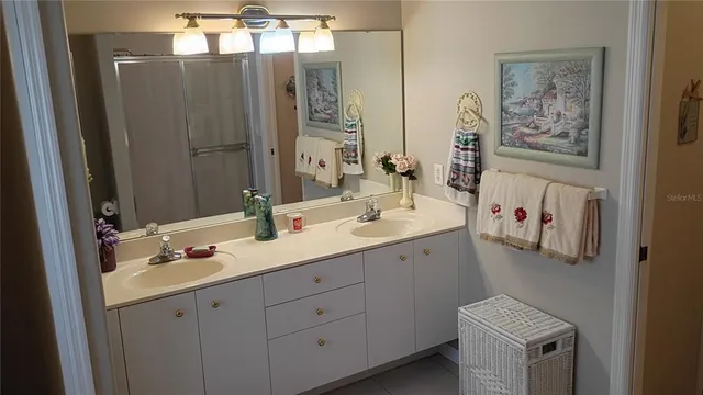 a view of a hallway to a room with wooden floor and chandelier