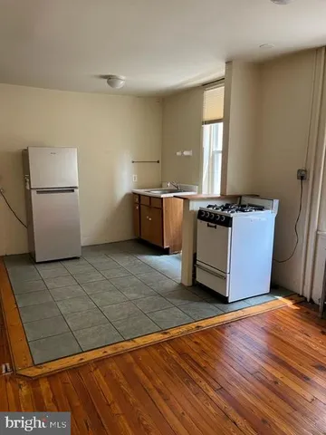 a kitchen with a stove a refrigerator and a more cabinets