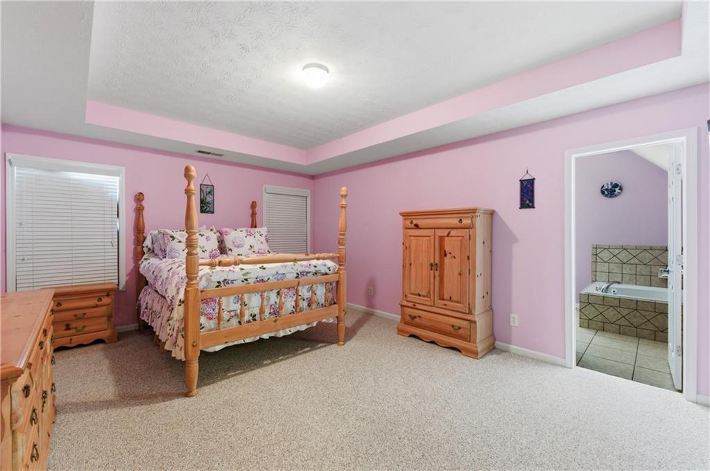 5980 Giles Road Lithonia, GA 30058 - Photo 25 of 38 a bedroom with a bed and wooden floor