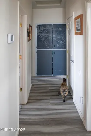 a view of a hallway with wooden floor and closet
