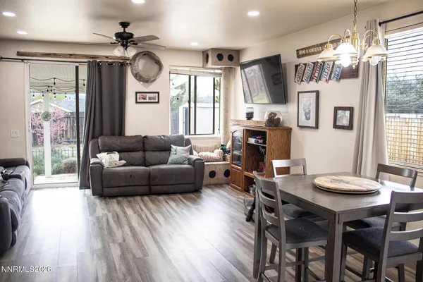 a living room with furniture a large window and wooden floor