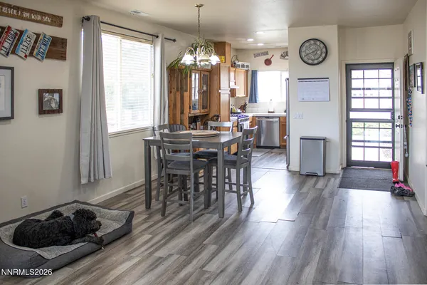 a view of a a dining room with furniture window and wooden floor