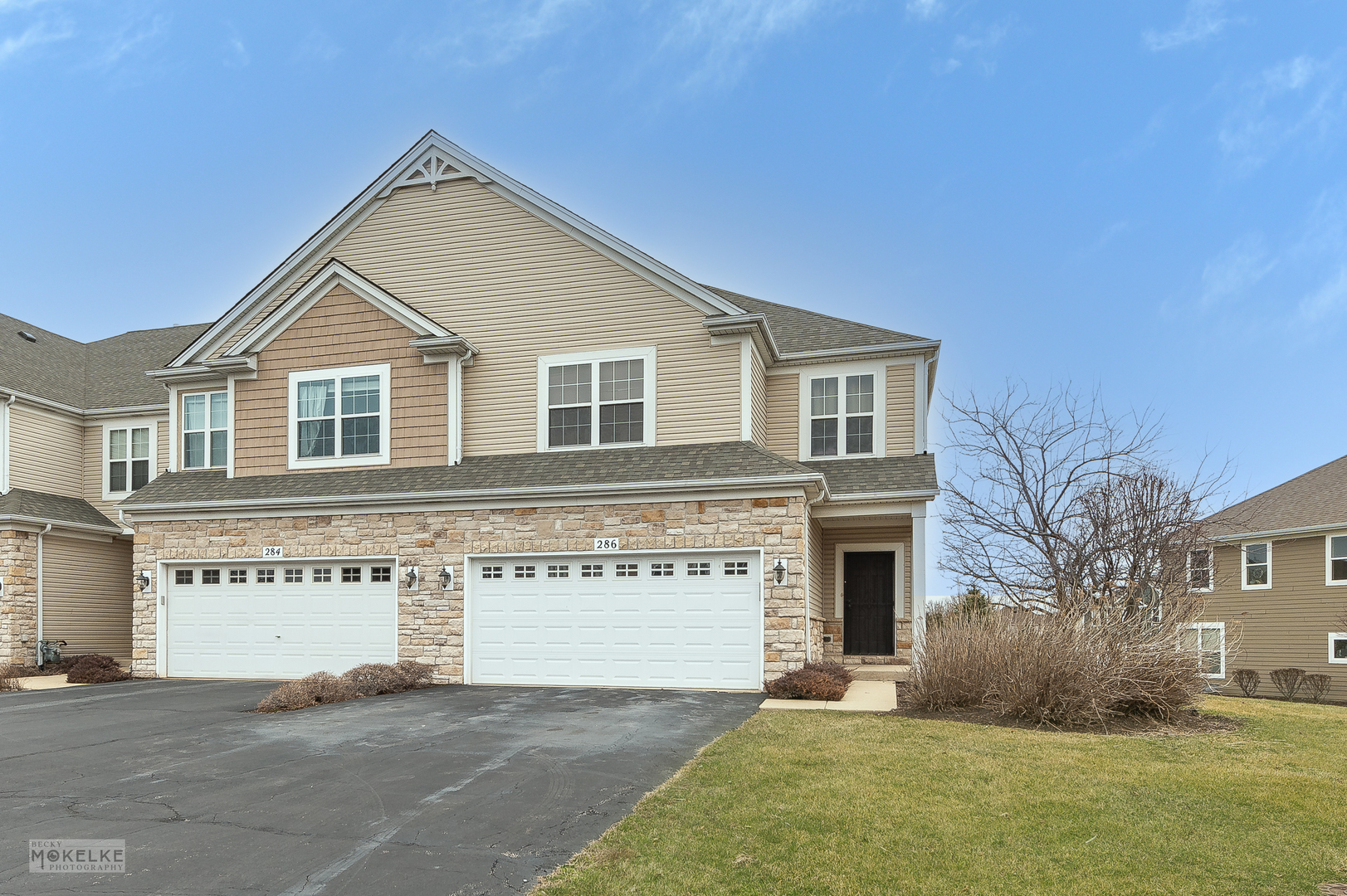 a front view of a house with a garden and yard