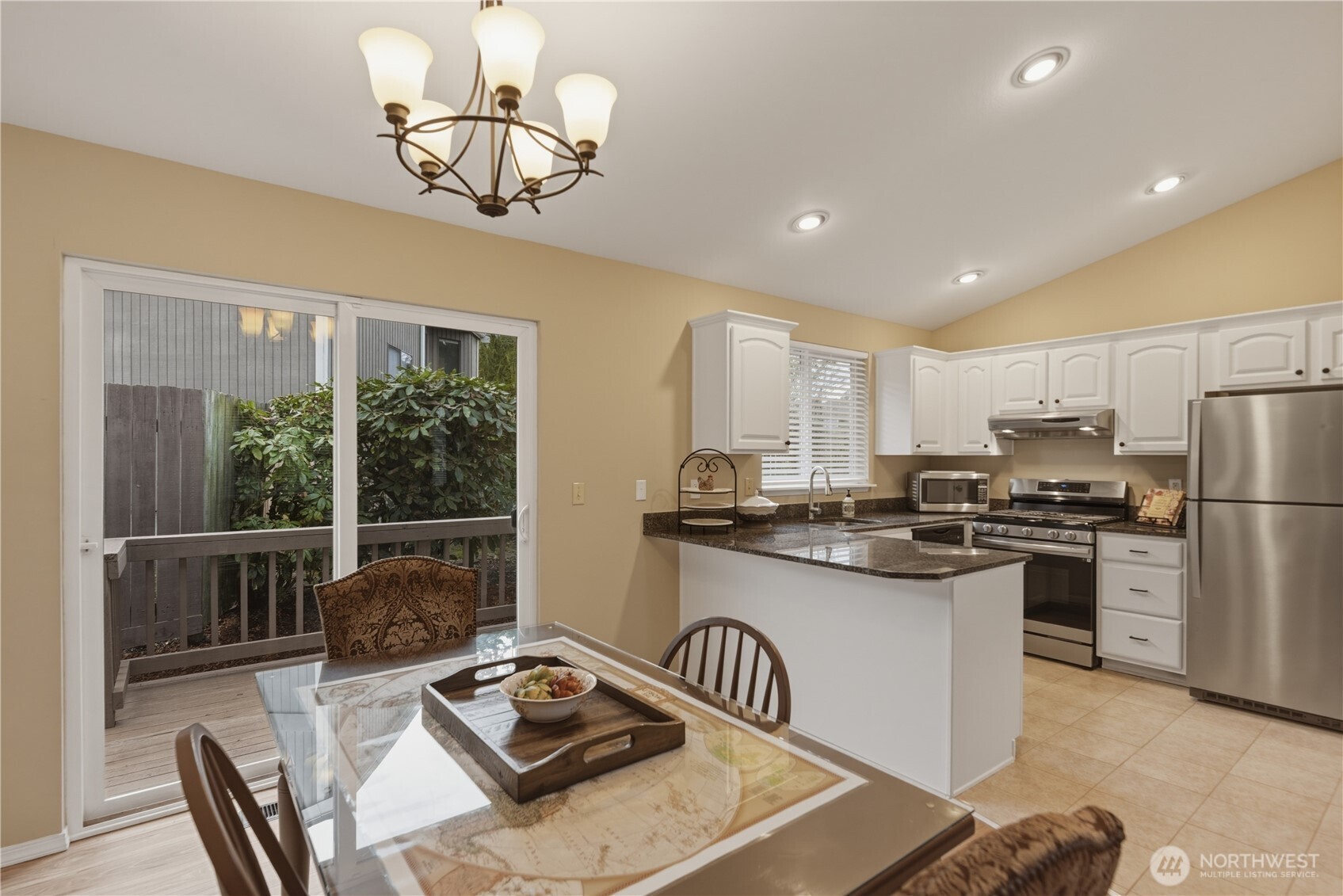 2415 Southeast 8th Place Renton, WA 98057 - Photo 11 of 39 a kitchen with stainless steel appliances granite countertop a sink a stove a refrigerator cabinets and chairs