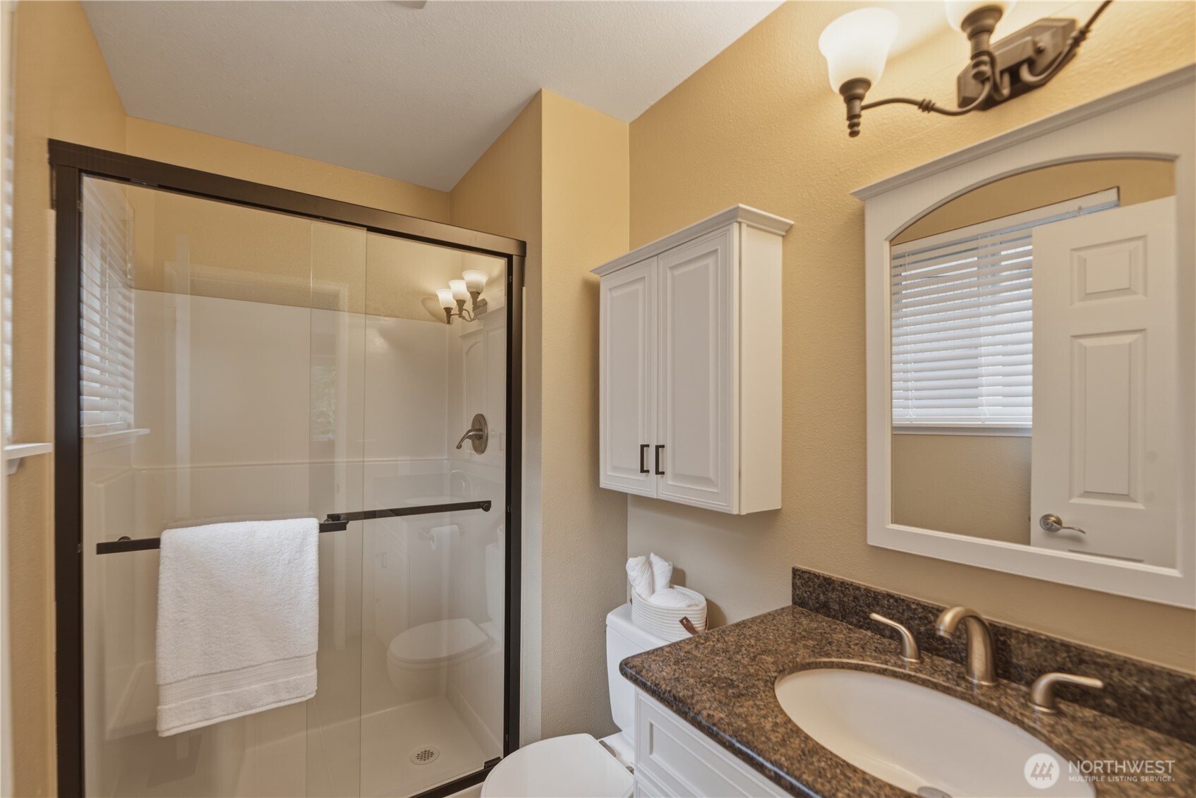 2415 Southeast 8th Place Renton, WA 98057 - Photo 17 of 39 a bathroom with a granite countertop sink a mirror and a shower