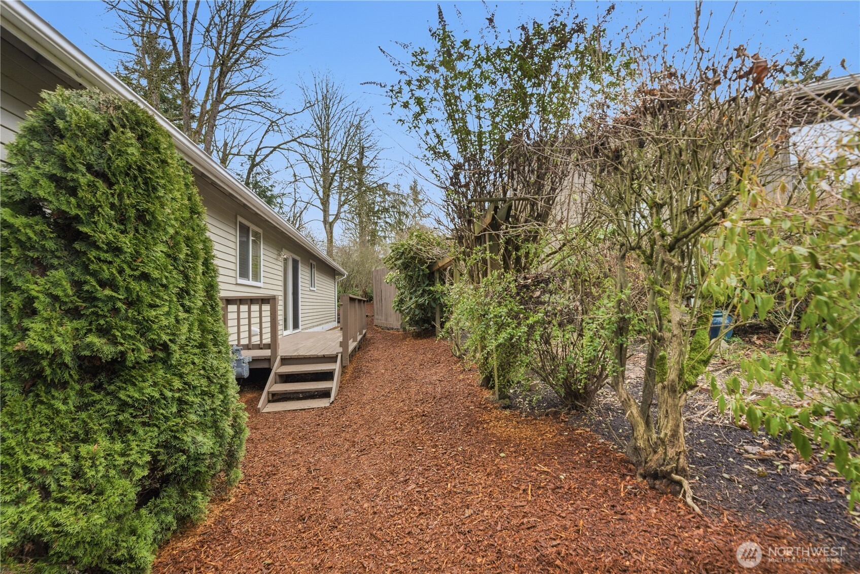 2415 Southeast 8th Place Renton, WA 98057 - Photo 26 of 39 a yellow house with trees in front of it