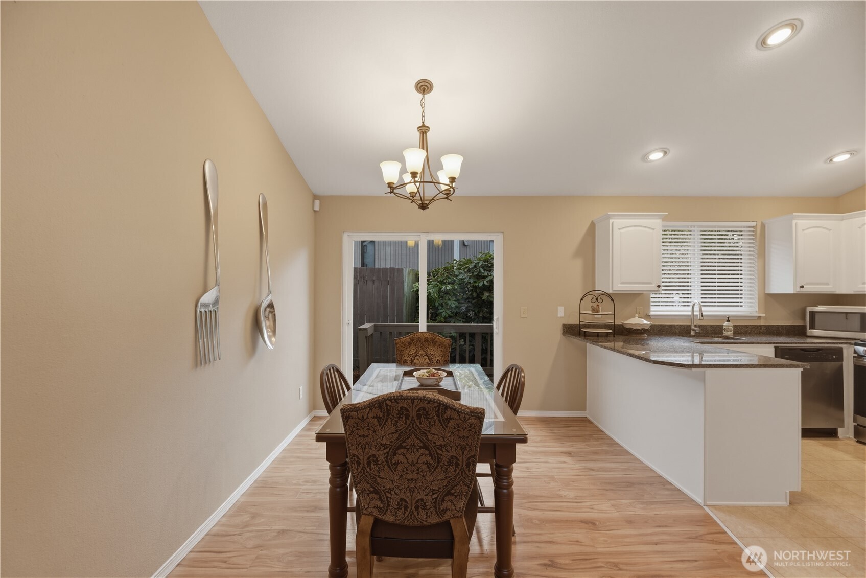 2415 Southeast 8th Place Renton, WA 98057 - Photo 32 of 39 a kitchen with stainless steel appliances granite countertop a stove top oven a sink dishwasher and a dining table with wooden floor