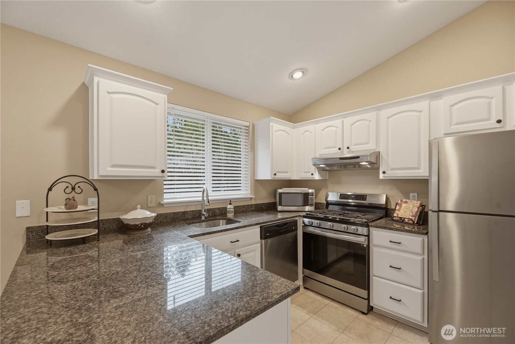 2415 Southeast 8th Place Renton, WA 98057 - Photo 7 of 39 a kitchen with granite countertop a sink stainless steel appliances and cabinets