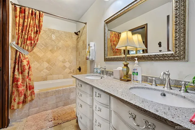 a bathroom with a granite countertop sink mirror and a bath tub