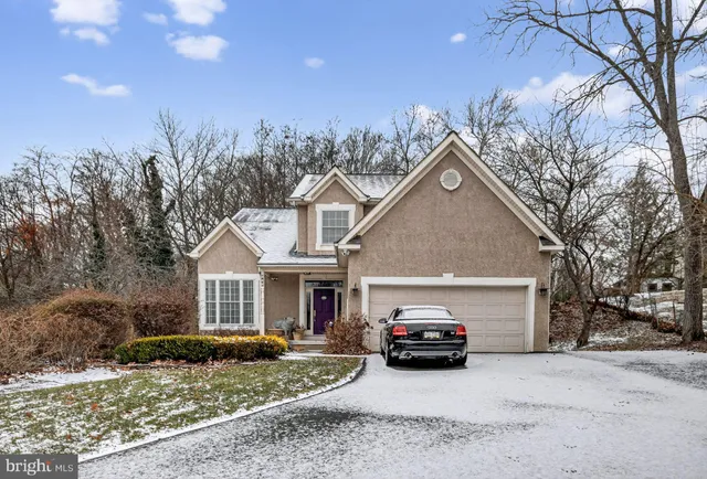 a view of a white house next to a yard and trees