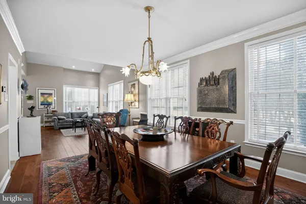 a view of a dining room and livingroom with furniture wooden floor a chandelier