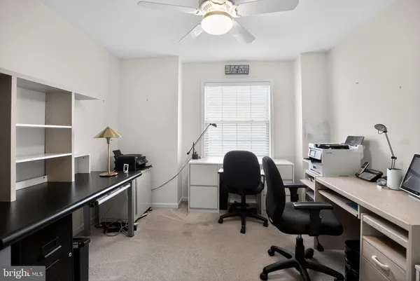 a view of a workspace with furniture and a window