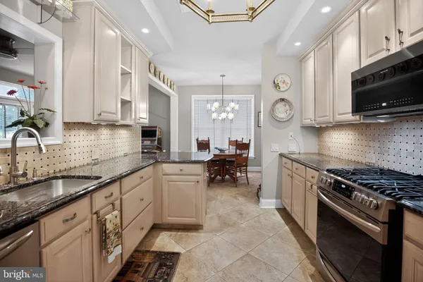 a kitchen with stainless steel appliances a sink a stove cabinets and a sink