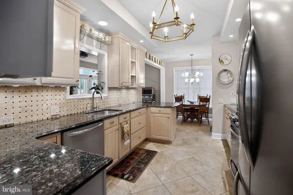 a large kitchen with a counter space a sink stainless steel appliances and cabinets