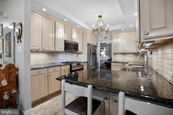 a kitchen with stainless steel appliances granite countertop a sink a stove and a refrigerator