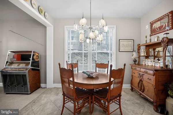 a dining room with furniture a chandelier and wooden floor