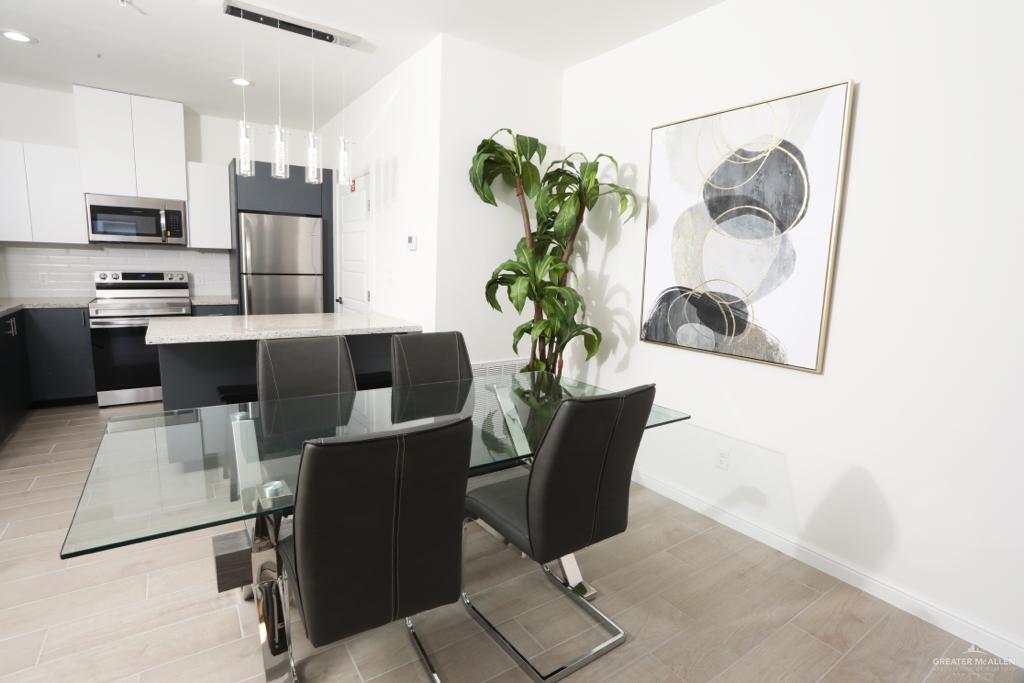 901 East Yuma Avenue, Unit 1806 McAllen, TX 78503 - Photo 5 of 12 a dining room with furniture and a potted plant