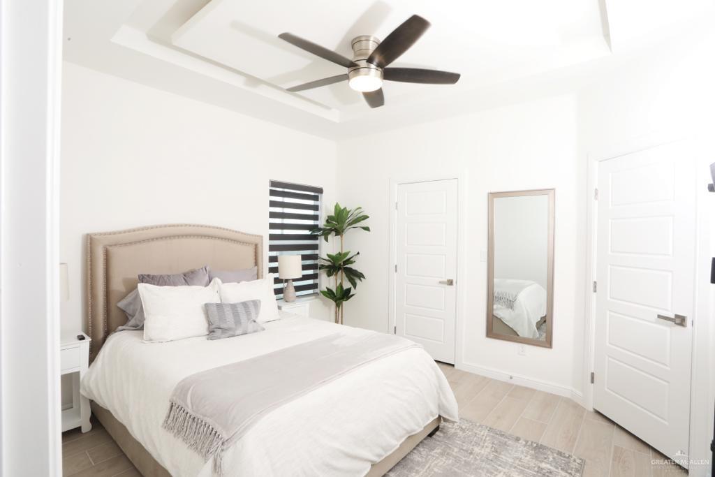 901 East Yuma Avenue, Unit 1806 McAllen, TX 78503 - Photo 8 of 12 a bedroom with a bed and a glass door