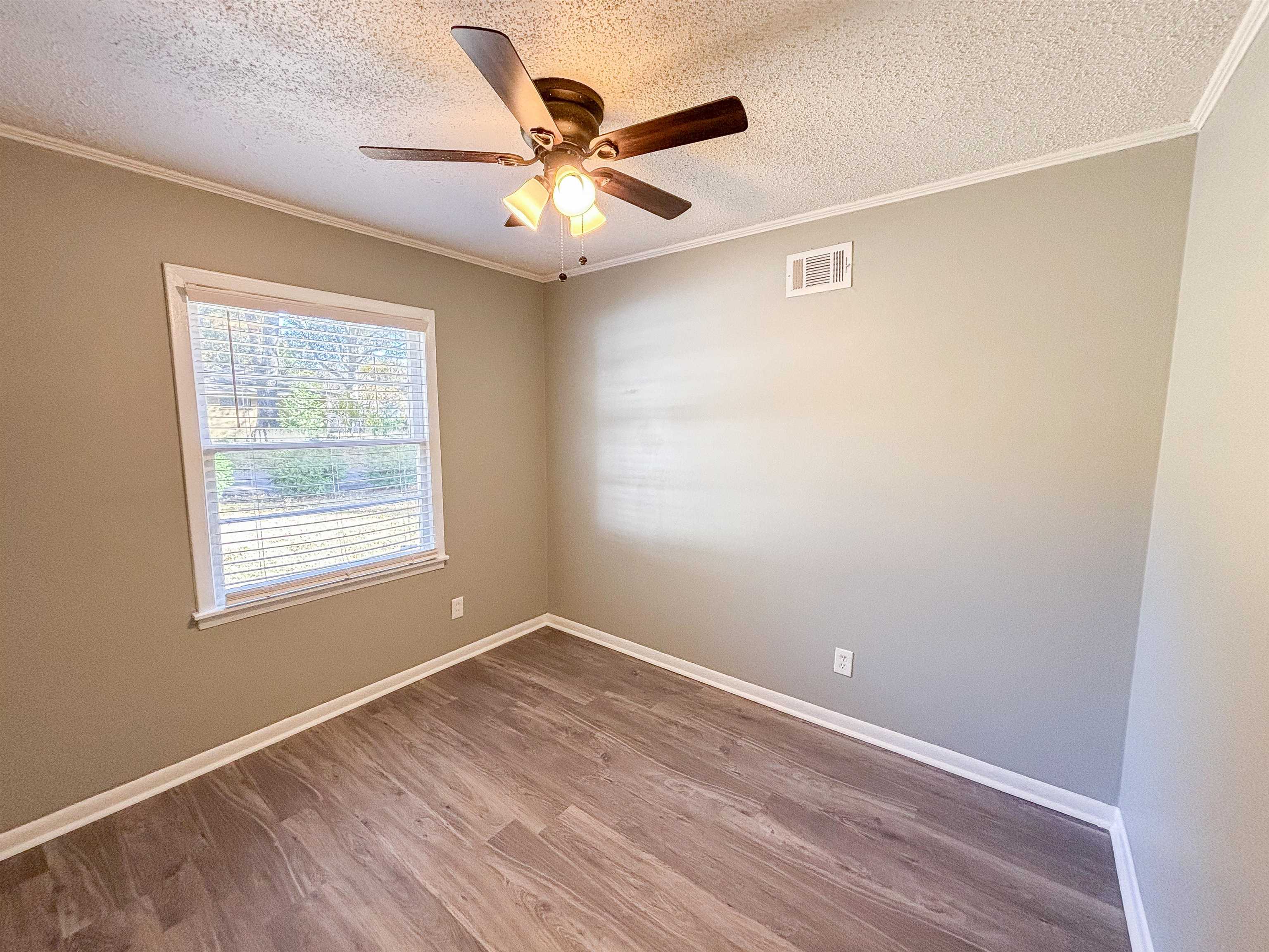 3057 Keats Road Bartlett, TN 38134 - Photo 14 of 23 Unfurnished room with a textured ceiling, wood finished floors, ornamental molding, and a ceiling fan