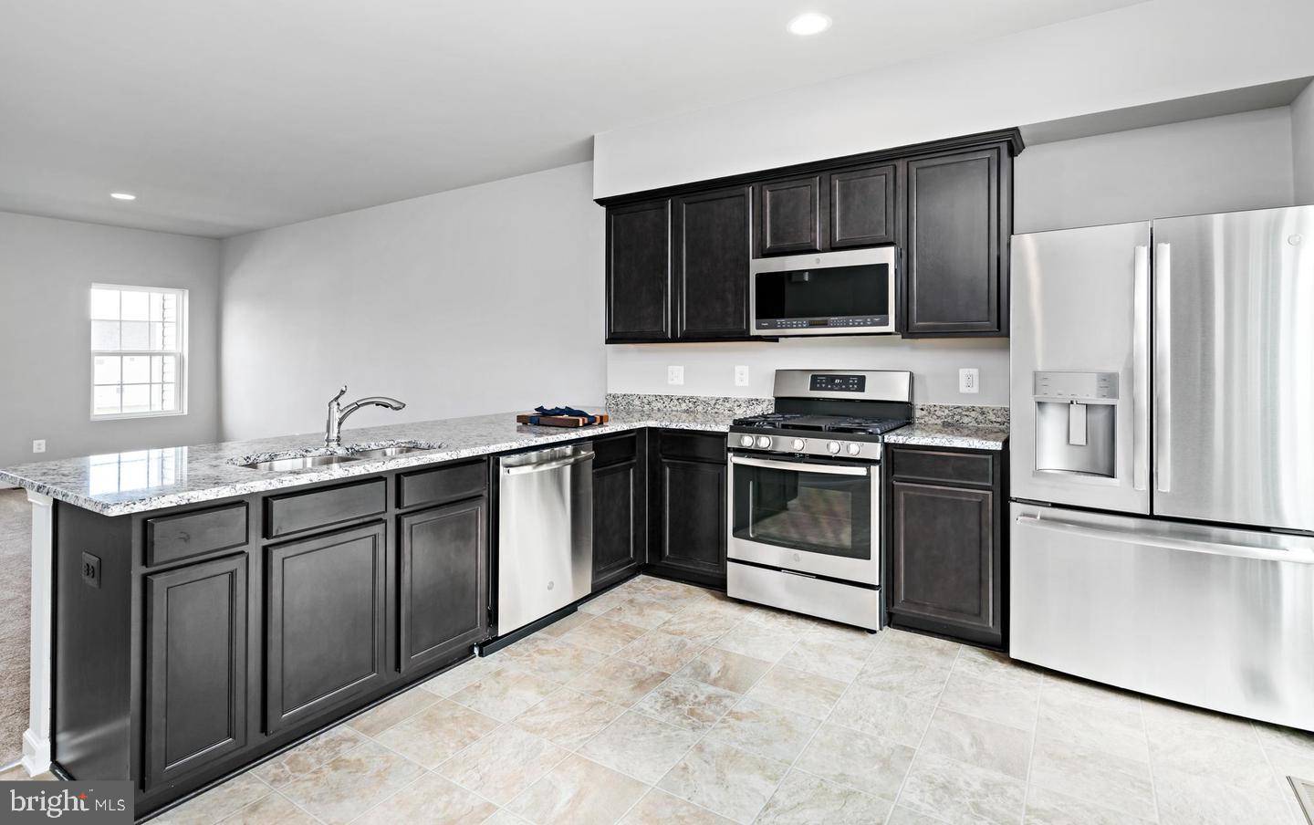 204 Parkland Drive Stephenson, VA 22656 - Photo 3 of 6 a kitchen with stainless steel appliances granite countertop a stove top oven a sink and a refrigerator
