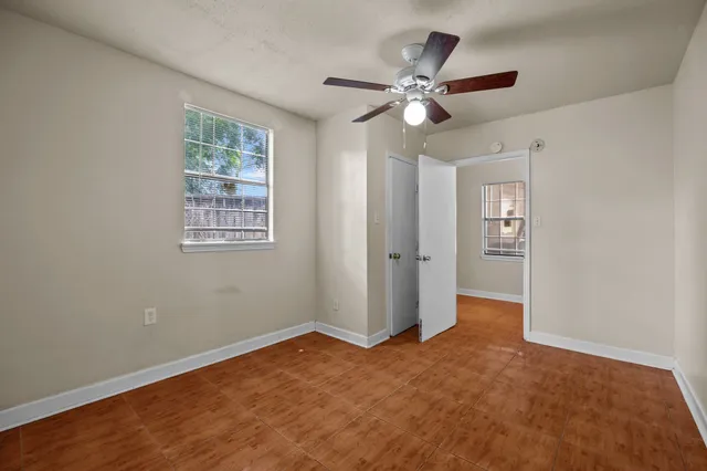 a view of a backyard with large trees and wooden fence