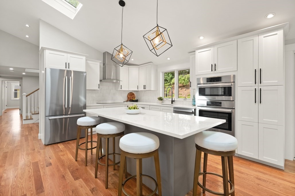 17 Saunders Road Lynnfield, MA 01940 - Photo 16 of 42 a kitchen with stainless steel appliances granite countertop a sink a stove a refrigerator cabinets and dining table