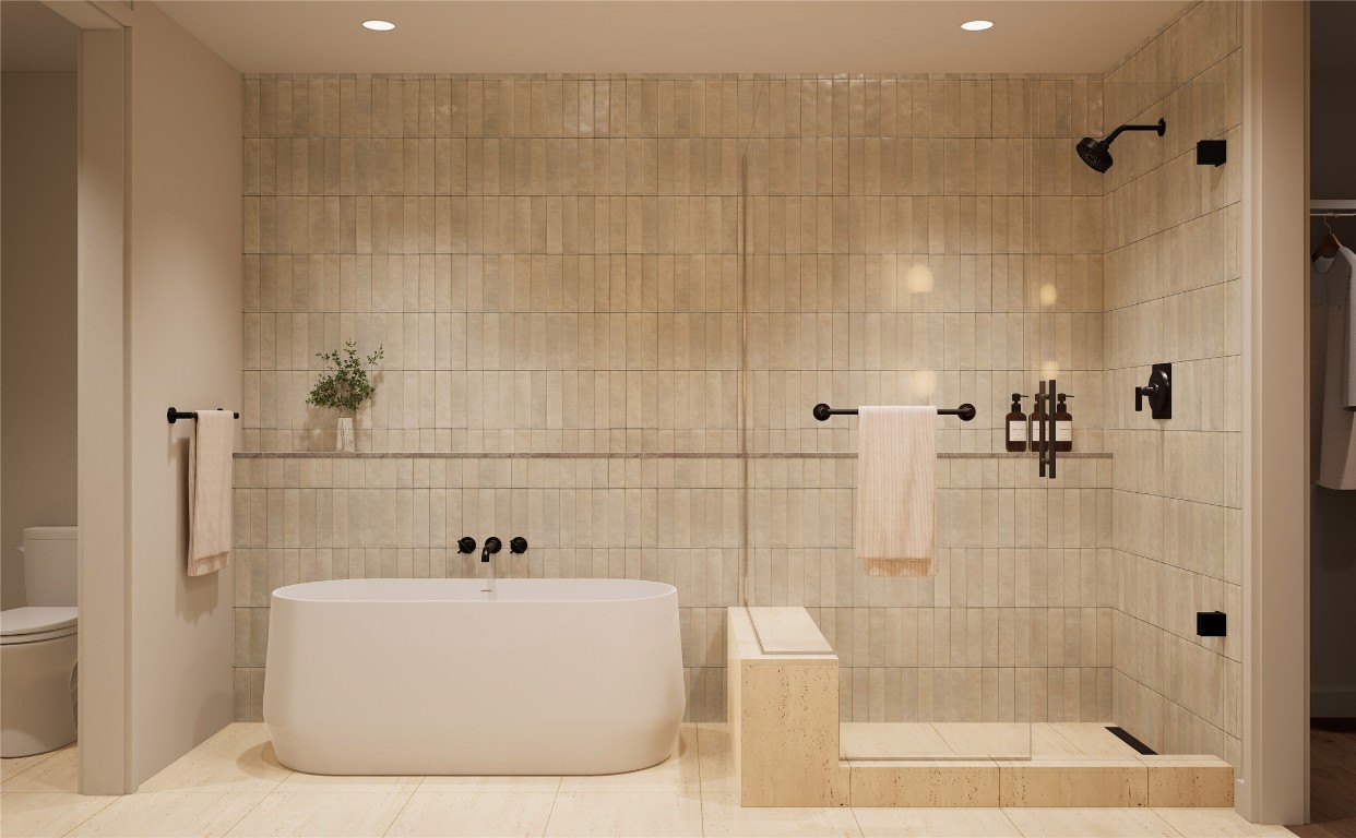 300 Pressler Street, Unit 216 Austin, TX 78703 - Photo 13 of 18 Primary bathroom in the Trailhead palette, featuring a walk-in shower, freestanding tub, tiled walls, travertine flooring, and recessed lighting. A serene, spa-inspired retreat designed to promote relaxation and comfort.