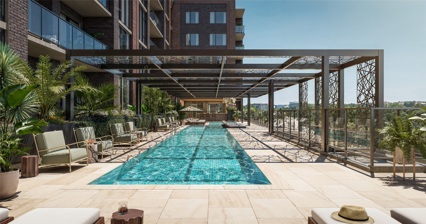 300 Pressler Street, Unit 216 Austin, TX 78703 - Photo 3 of 18 Resort-style pool deck featuring a 75-foot lap pool, tanning ledge, and shaded lounge areas. Designed for both relaxation and recreation, the pool is located adjacent to the resident lounge and bar for a connected indoor-outdoor experience.