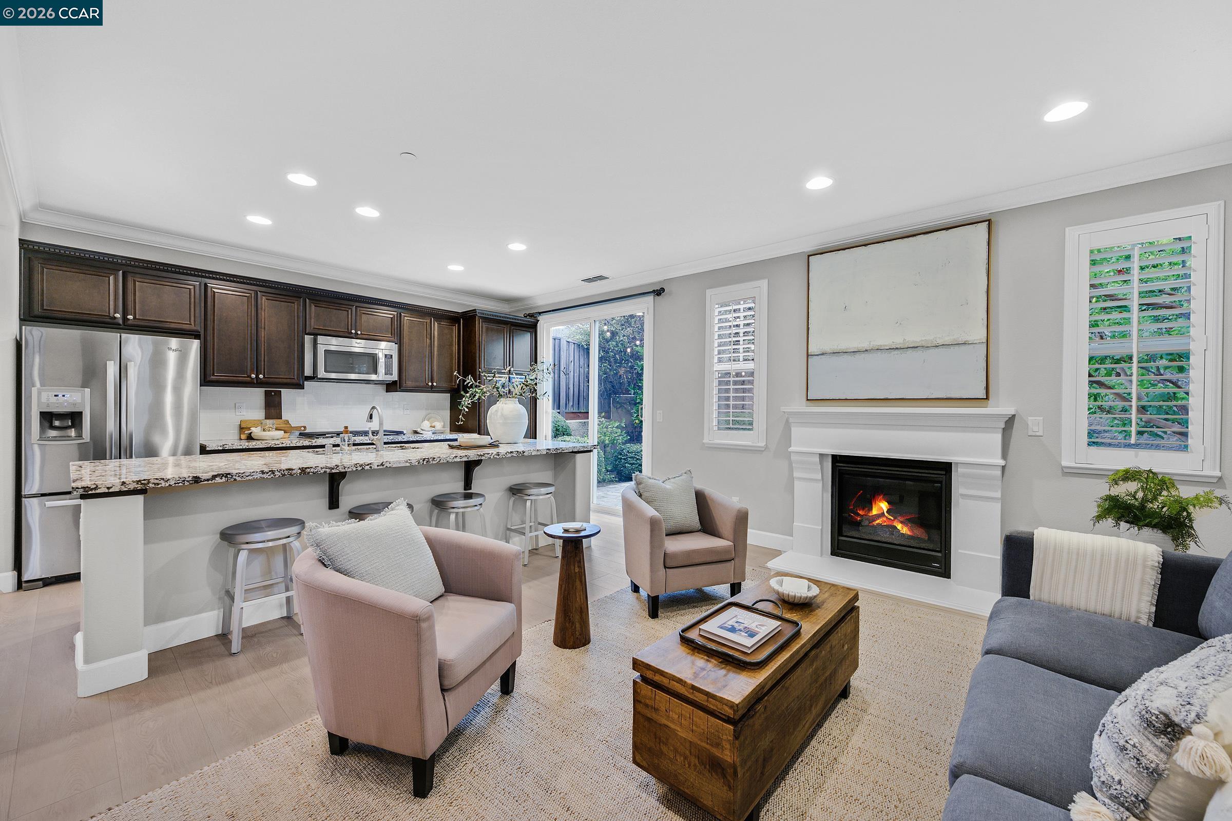 111 Elworthy Ranch Drive Danville, CA 94526 - Photo 6 of 43 a living room with furniture a fireplace and kitchen view