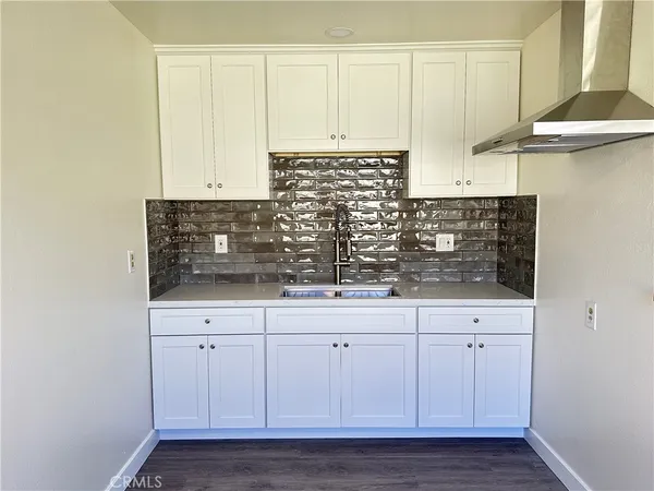 a kitchen with white cabinets and a sink
