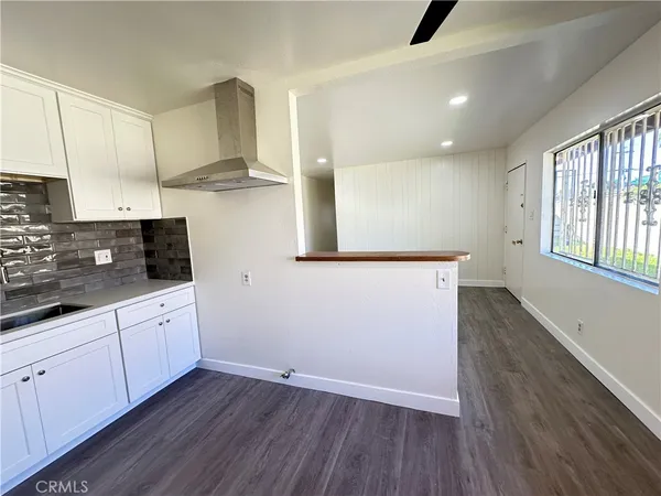 a view of a kitchen with wooden floor and electronic appliances