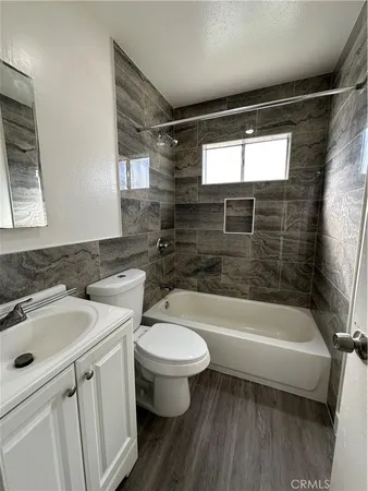 a bathroom with a sink a toilet a bathtub and shower
