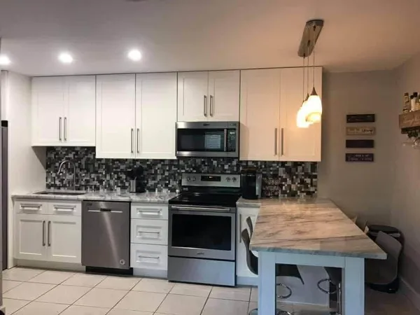 a kitchen with granite countertop a stove top oven microwave and cabinets