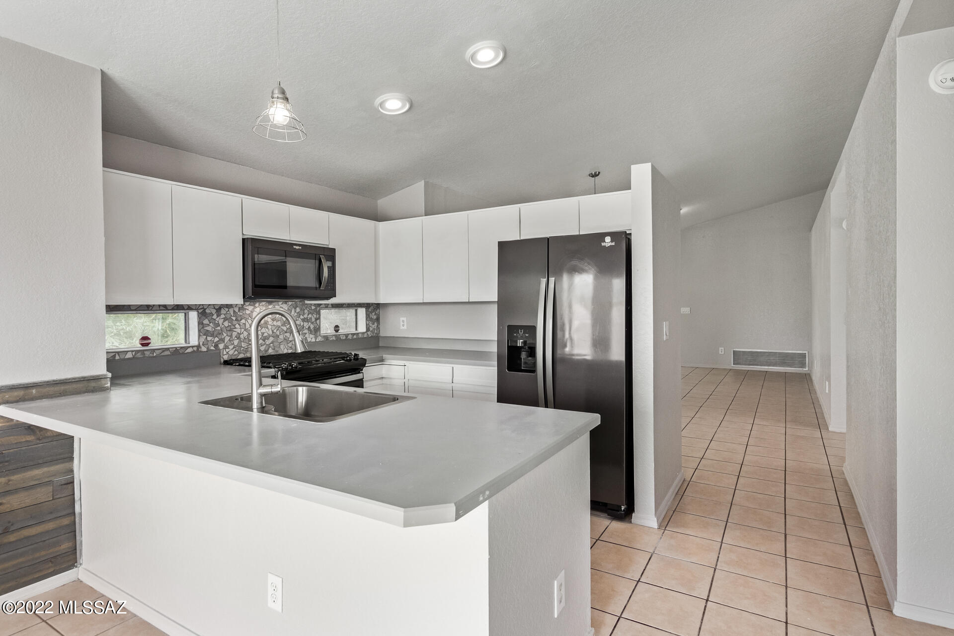 4697 West Weathervane Street Tucson, AZ 85741 - Photo 11 of 25 a kitchen with sink a microwave and refrigerator