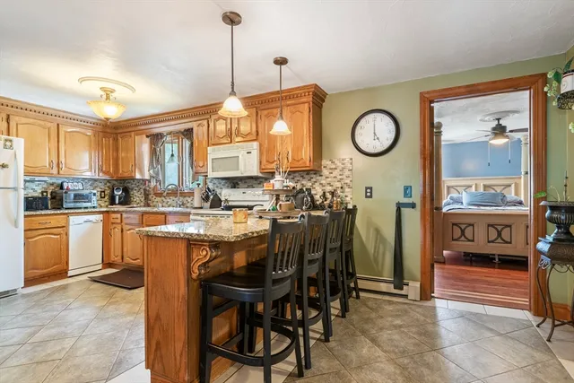 a dining hall with stainless steel appliances granite countertop a stove and a refrigerator