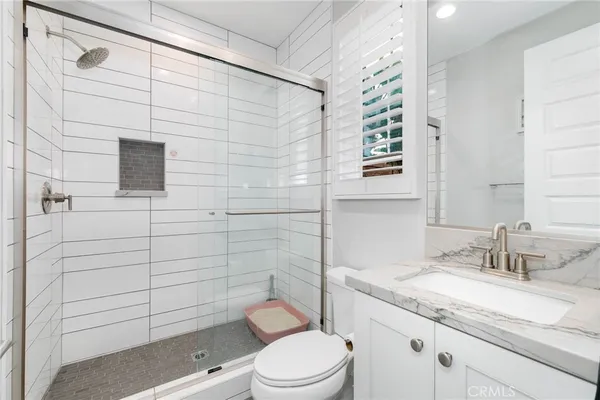 a bathroom with a granite countertop toilet sink and mirror