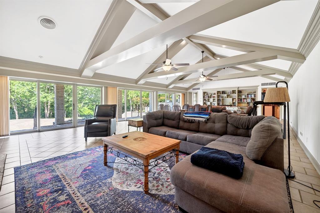 1901 Rose Pointe Athens, TX 75752 - Photo 4 of 37 Expansive living area featuring a vaulted ceiling with exposed beams, tile flooring, and a wall of sliding glass doors